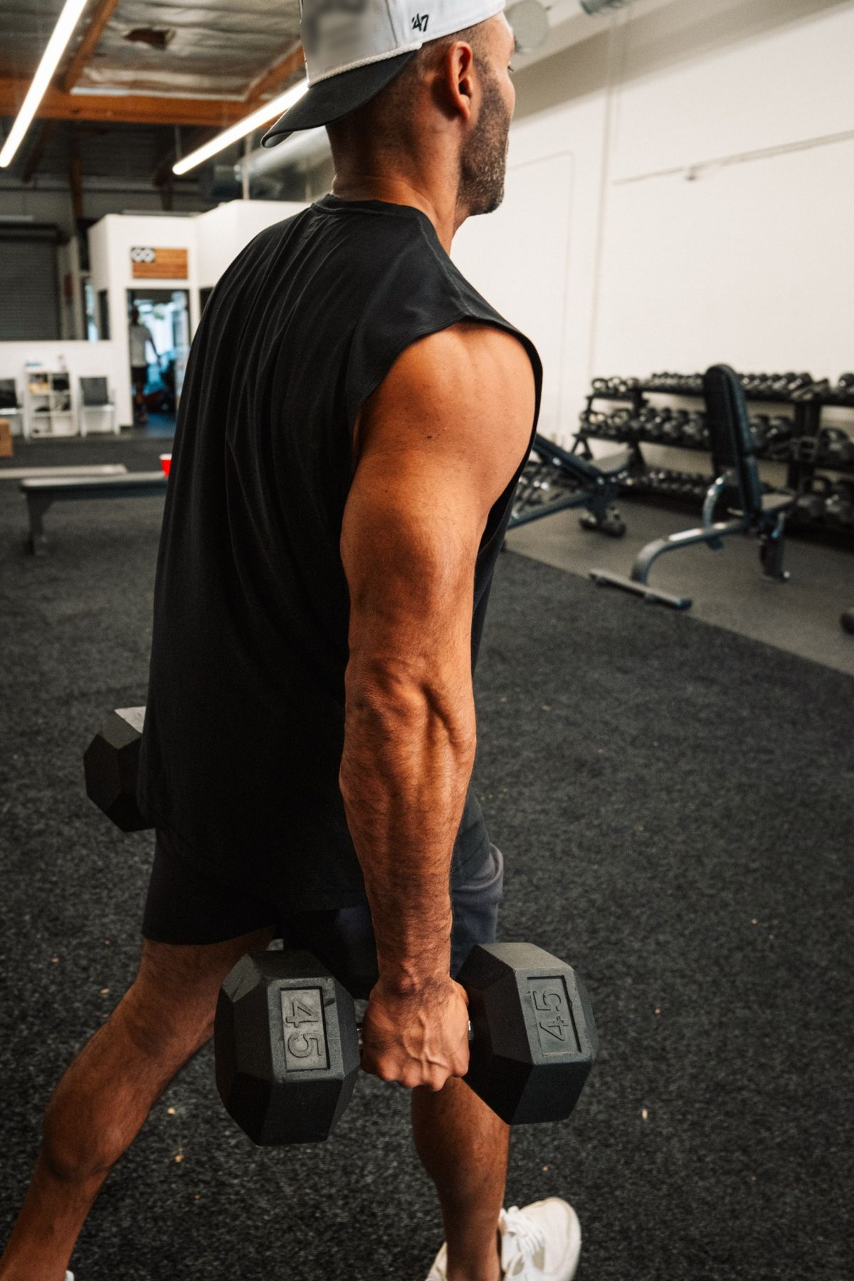 Nick carrying heavy dumbbells across the gym